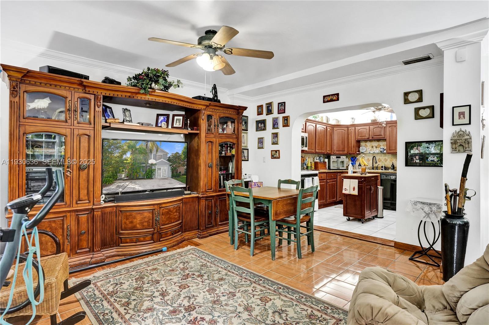 A living room with a large wooden entertainment center, dining table, and adjacent kitchen — 11728 SW 118th Ter, Miami FL 33186, MIAMI, FL