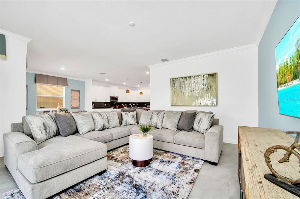 A living room features a large gray sectional sofa, a patterned rug, and a television — 2661 PETITION LANE, KISSIMMEE, FL