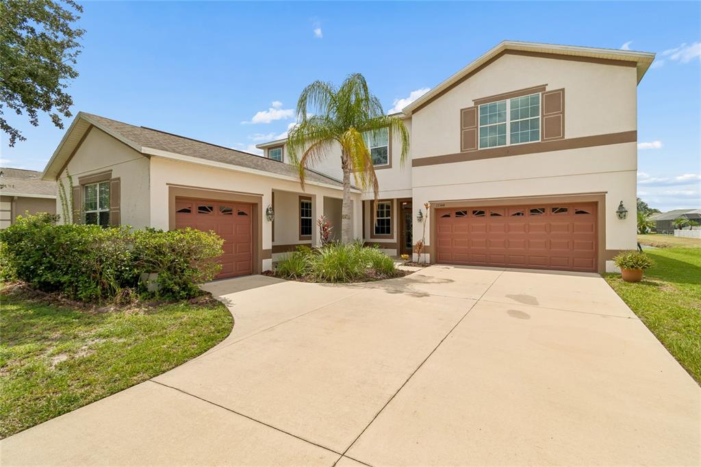 A two-story house with a beige exterior, brown trim, and a three-car garage — 13344 GRAHAM YARDEN, RIVERVIEW, FL