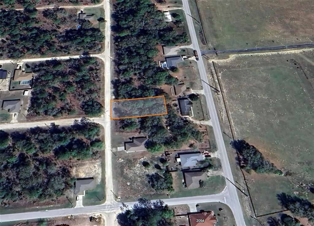 An aerial view shows a rectangular vacant lot outlined in orange within a residential neighborhood — 00 SW 140TH COURT, OCALA, FL