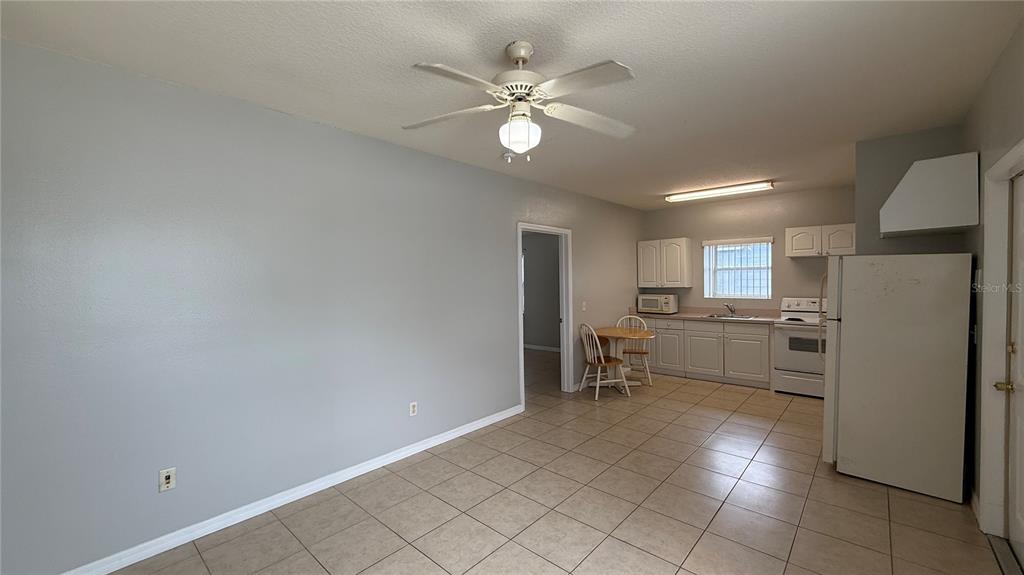 A kitchen and dining area with tile flooring, white cabinets, and a ceiling fan — 627 ORCHID DRIVE, DAVENPORT, FL