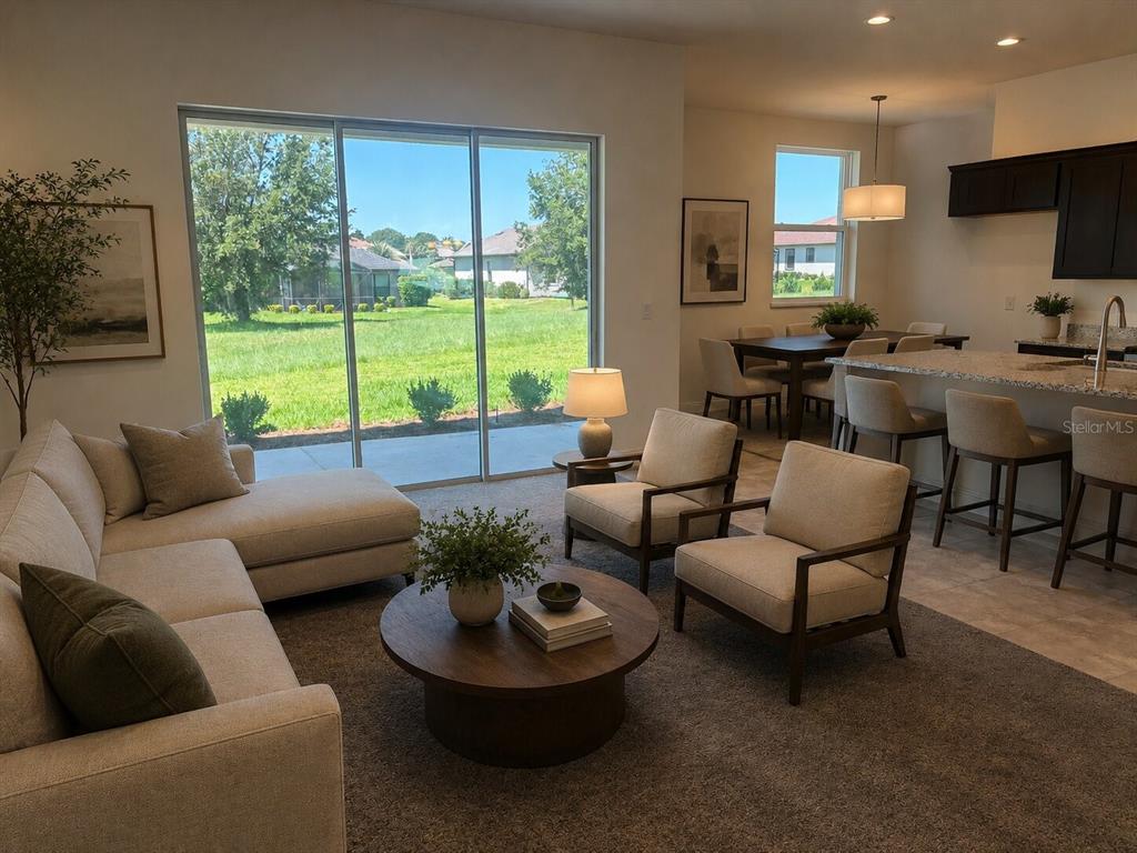 A living room with a sectional sofa, two armchairs, and a kitchen with bar seating — 5540 SADDLEBACK COURT, LADY LAKE, FL
