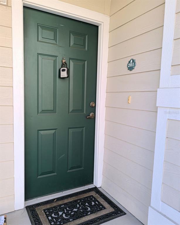 A green front door with a lockbox and a number 201 sign on the wall — 131 SOUTHERN PECAN CIRCLE UNIT 201, WINTER GARDEN, FL
