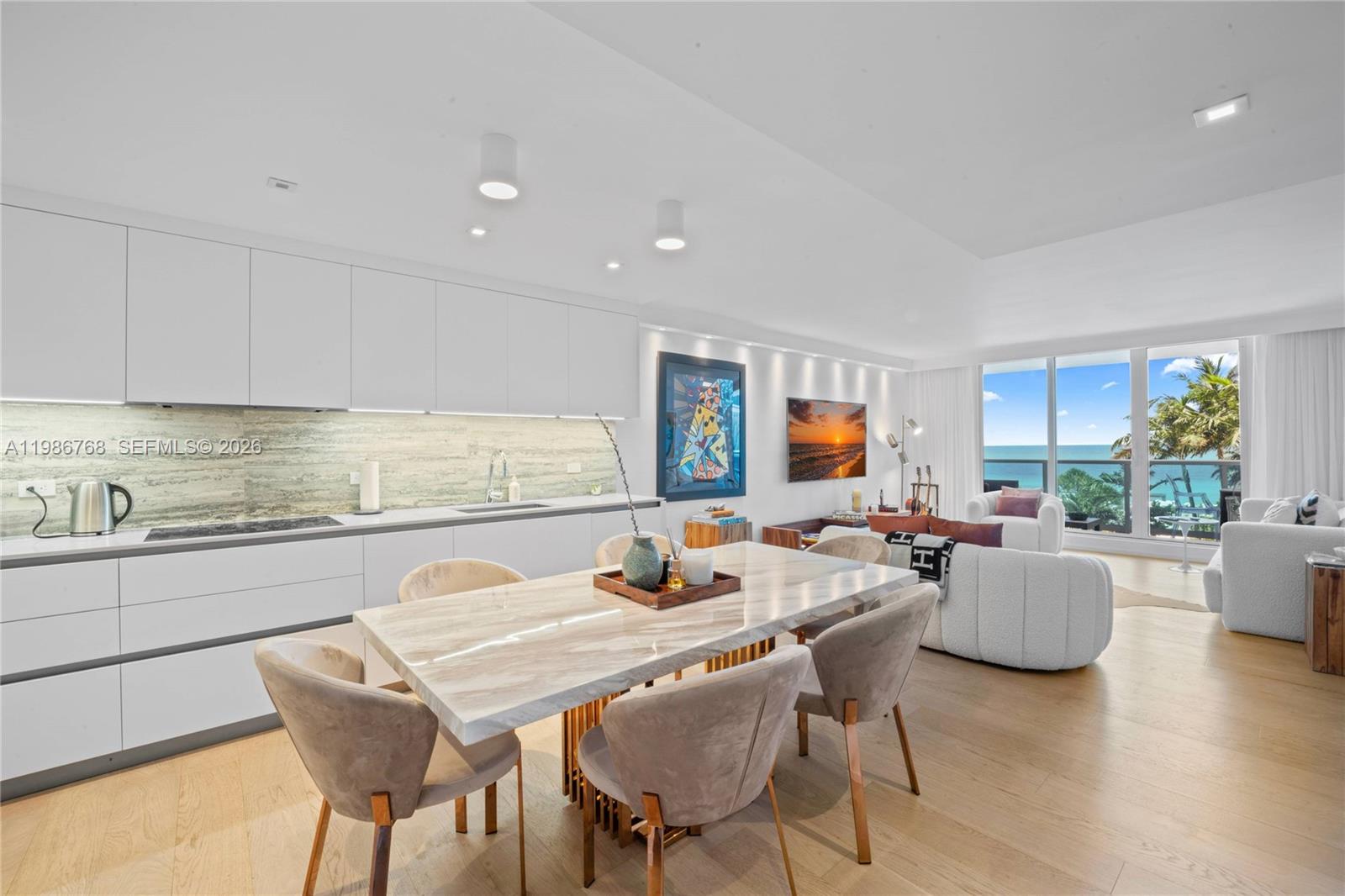 A modern open-concept kitchen and dining area features a marble table and ocean views — 2301 Collins Ave # 624, Miami Beach FL 33139, MIAMI BEACH, FL