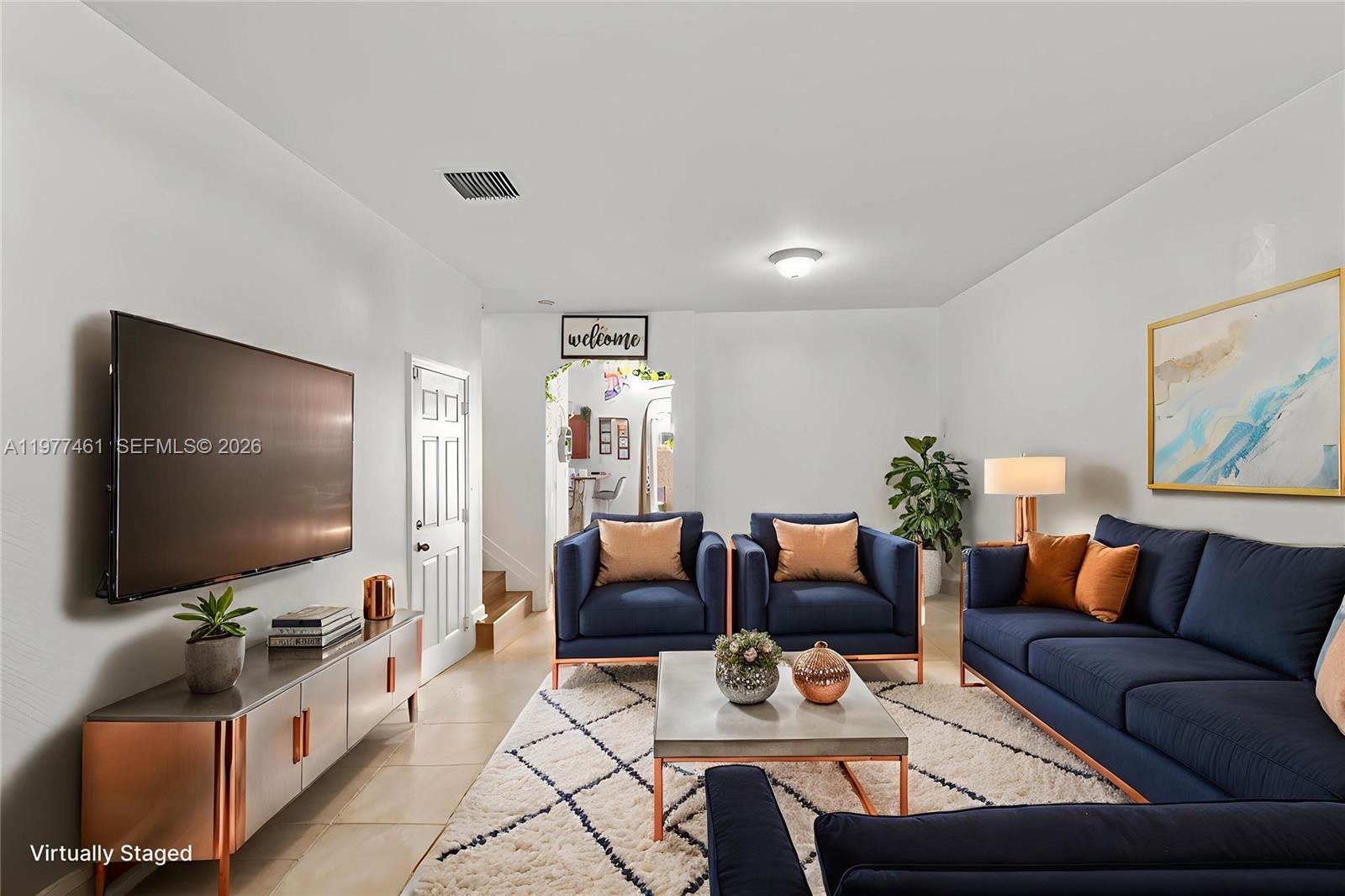 A living room features navy blue furniture, a patterned rug, and a wall-mounted television — 12958 SW 135th St, Miami FL 33186, MIAMI, FL