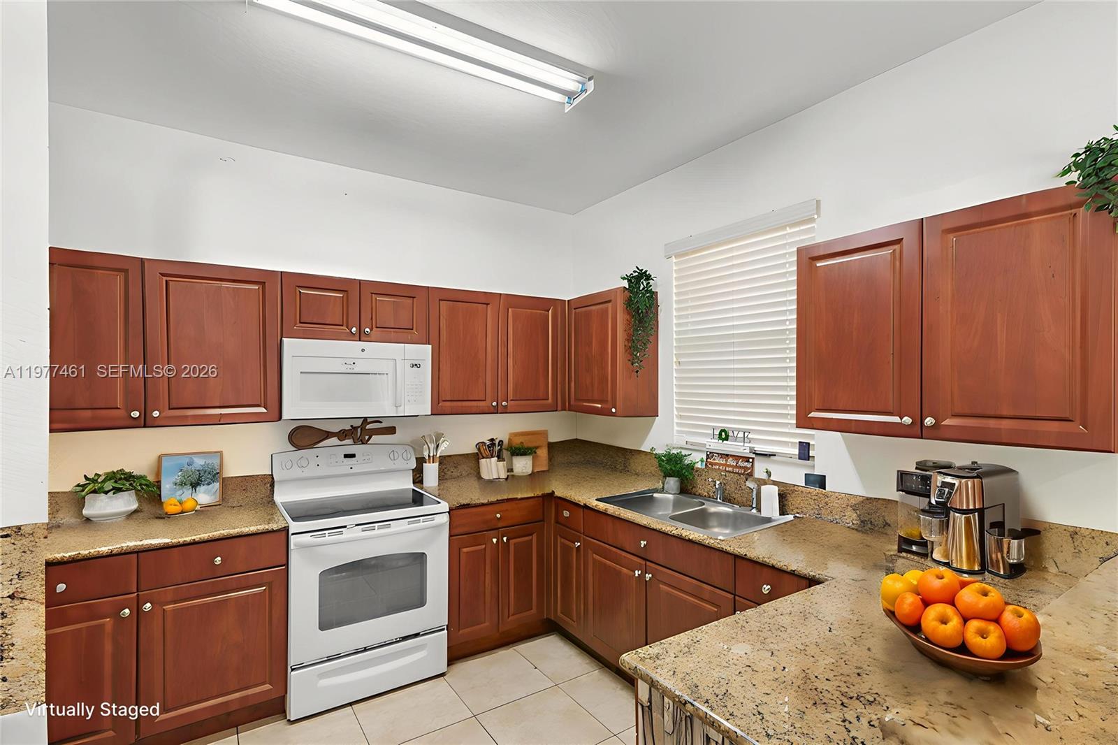 A kitchen features wood cabinets, granite countertops, white appliances, and a double basin sink — 12958 SW 135th St, Miami FL 33186, MIAMI, FL