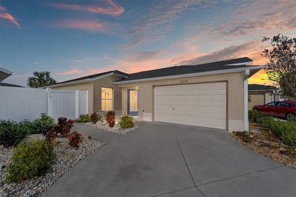 A kitchen features wood cabinets, a white stove, a microwave, and a stainless steel refrigerator — 2303 NAUTILUS LANE, THE VILLAGES, FL