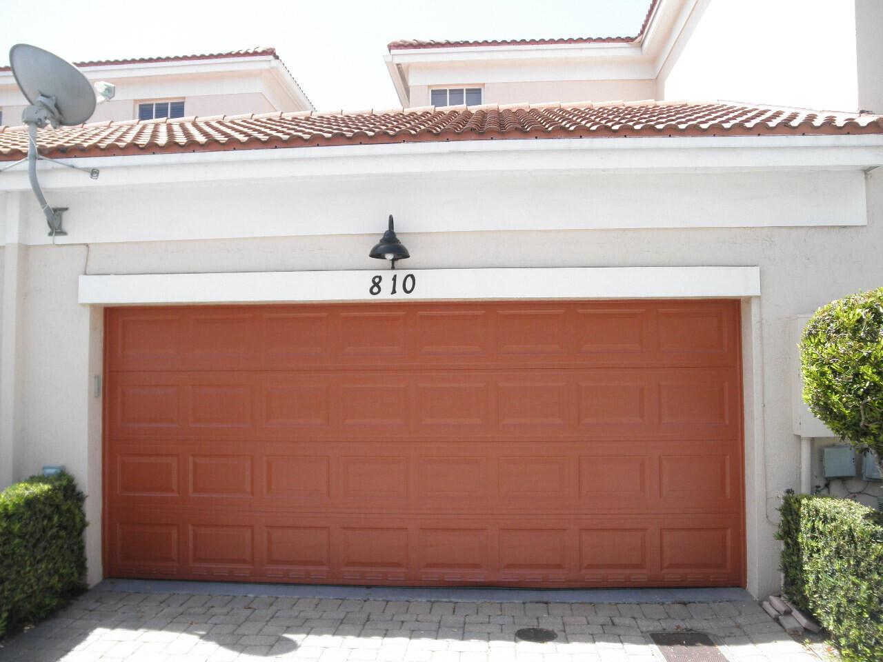 A residential garage door with a terracotta finish sits beneath a tiled roof — BOCA RATON, FL