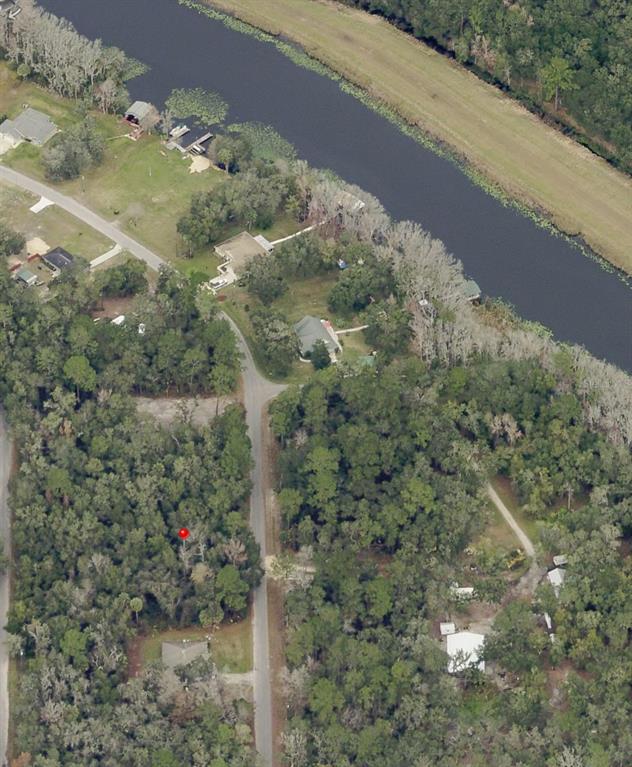 This aerial view shows a wooded residential area with a river and several houses — 0 SEQUOIA DRIVE, OCKLAWAHA, FL