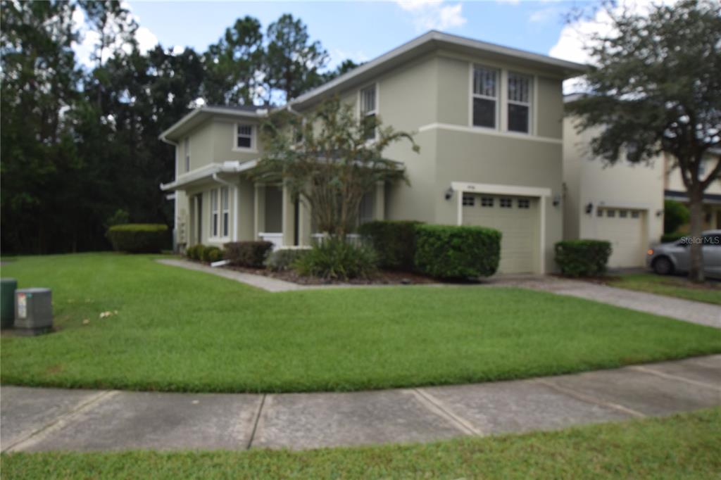 A two-story house with a light green exterior, a front porch, and an attached garage — 9796 TIVOLI VILLA DRIVE, ORLANDO, FL
