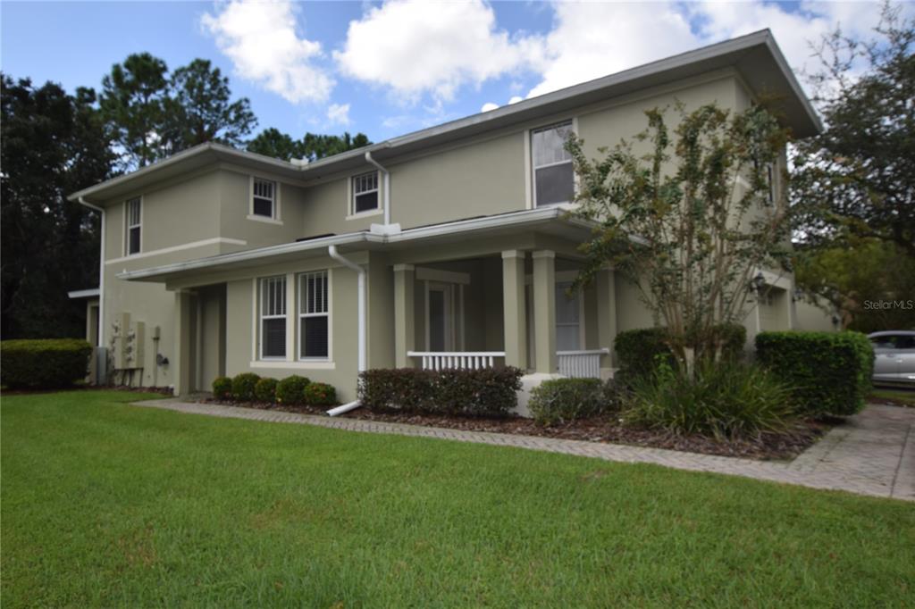 A two-story house with light green stucco siding and a covered front porch — 9796 TIVOLI VILLA DRIVE, ORLANDO, FL