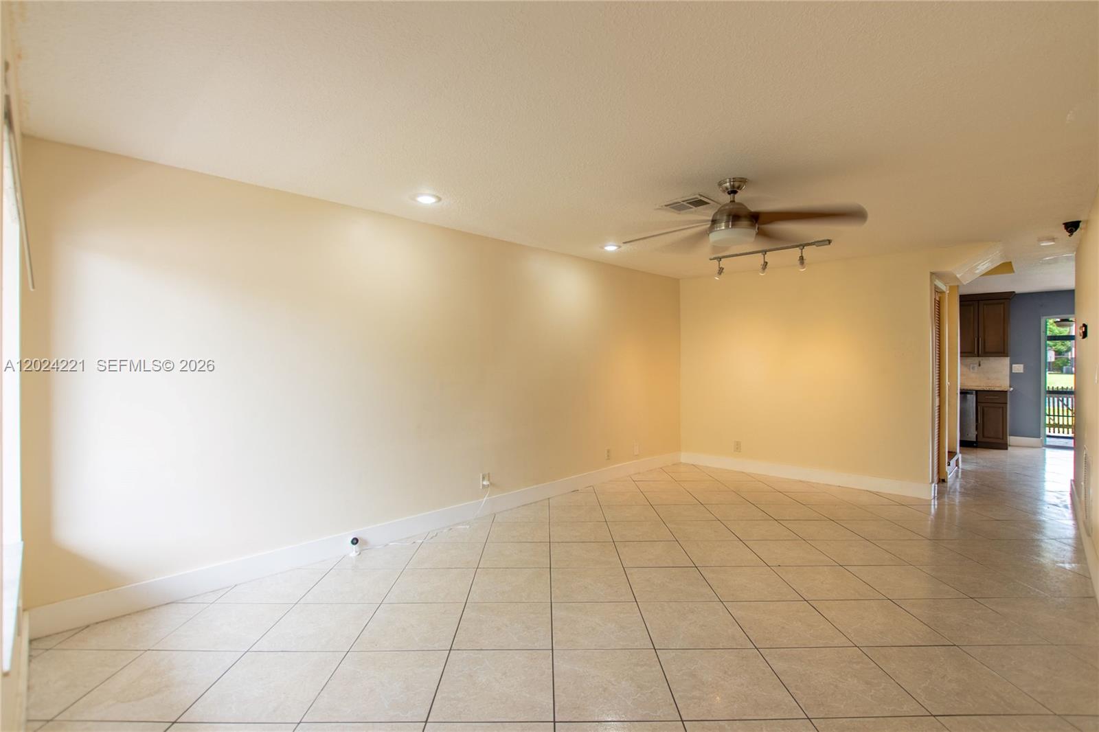 A bright, tiled living room features a ceiling fan and an adjacent kitchen area — 9803 NW 37th St, Sunrise FL 33351, SUNRISE, FL