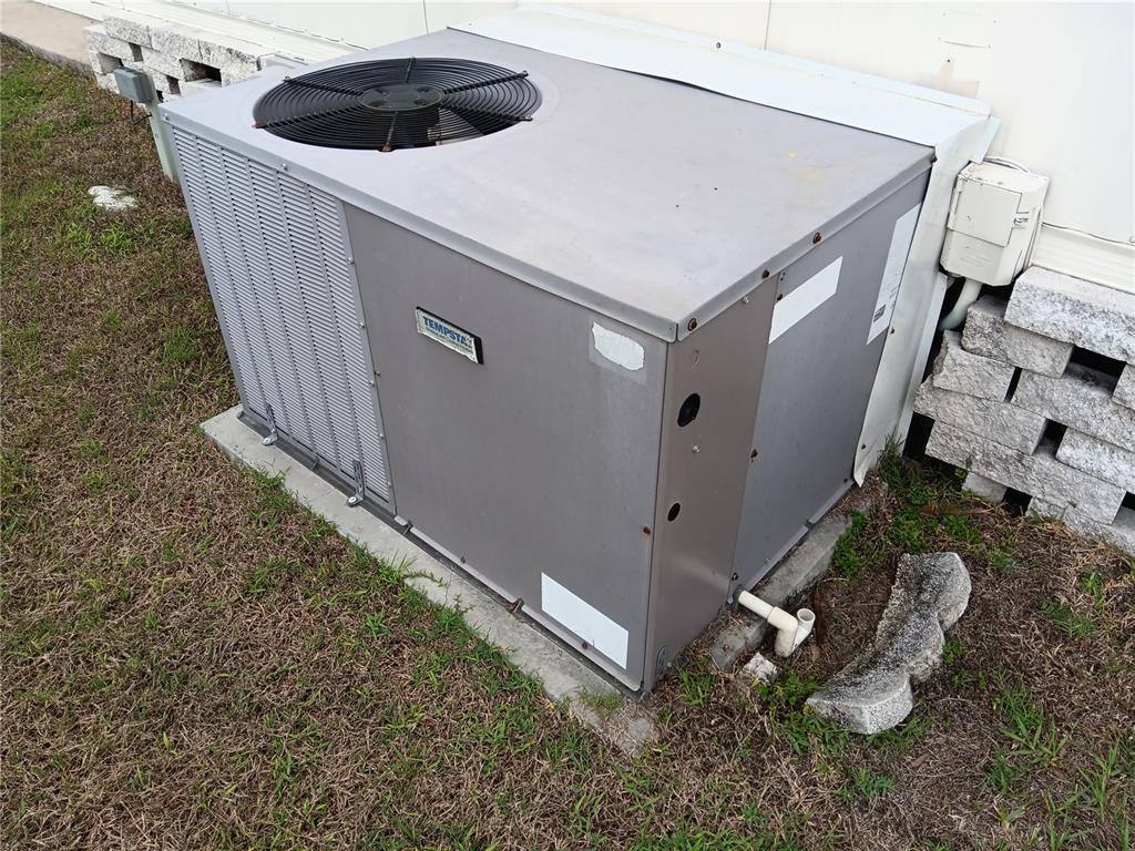 An outdoor Tempstar air conditioning unit sits on a concrete pad next to a building — 37536 AMIGO DRIVE, ZEPHYRHILLS, FL