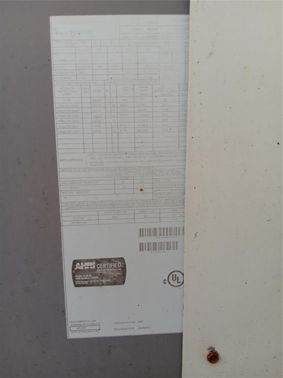 A close-up view of an HVAC unit's technical specification label attached to a metal panel — 37536 AMIGO DRIVE, ZEPHYRHILLS, FL