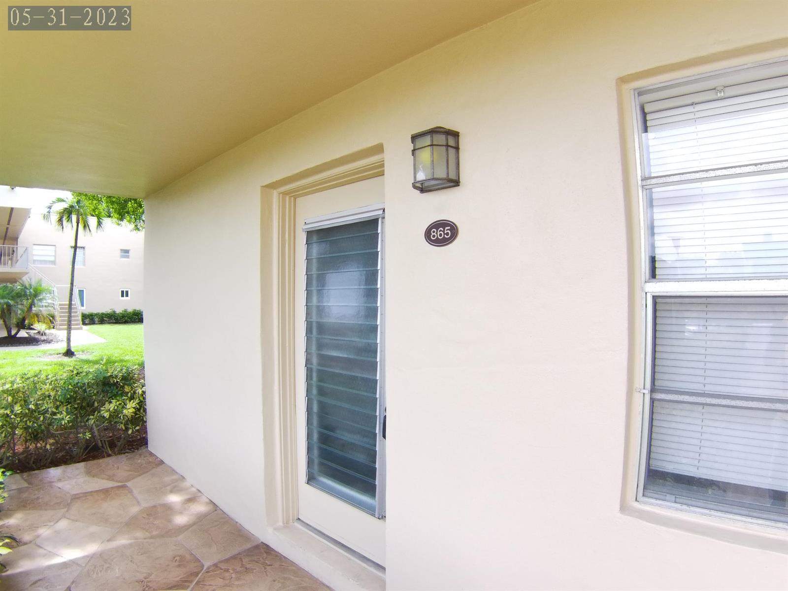 A beige exterior wall features a door with a louvered window and a house number — 865 Flanders S, Delray Beach FL 33484, DELRAY BEACH, FL