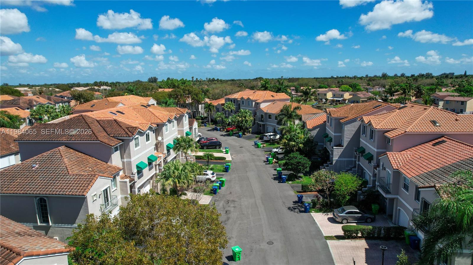 An aerial view shows a residential street lined with multi-story townhouses featuring terracotta tile roofs — 1354 NW 126th Way, Sunrise FL 33323, SUNRISE, FL