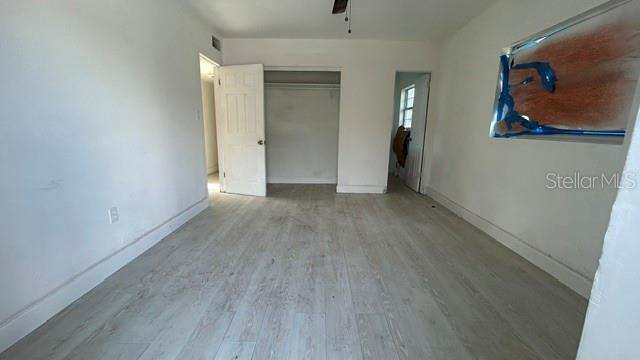 An empty room with light wood-look flooring, white walls, and two open doorways — 2506 SANDY LANE, ORLANDO, FL