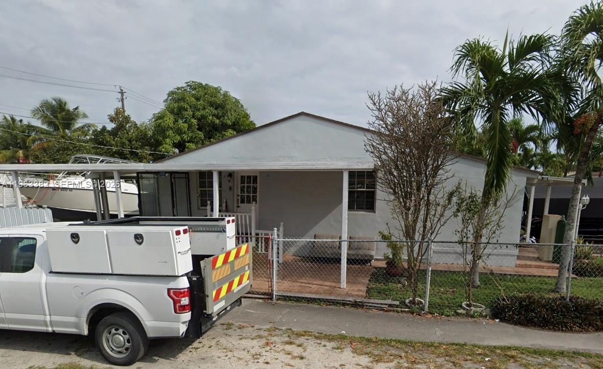 A single-story house with a covered front porch, chain-link fence, and a parked utility truck — 501 SE 1st St, Hialeah FL 33010, HIALEAH, FL