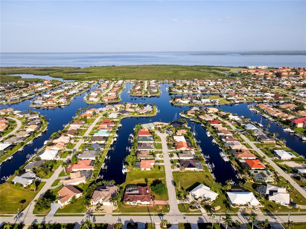 An aerial view of a residential neighborhood with houses situated along interconnected canals — 2500 RIO LISBO COURT, PUNTA GORDA, FL