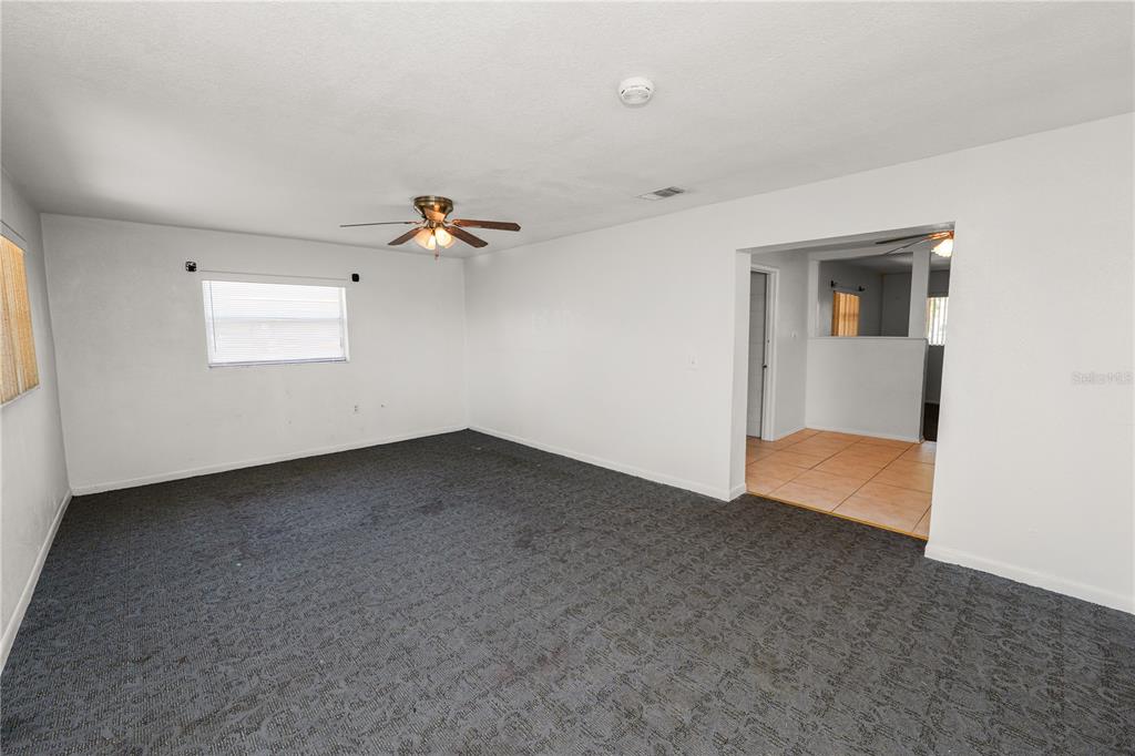An empty living room features gray carpet, white walls, and a ceiling fan — 2170 ROHR DRIVE, BARTOW, FL