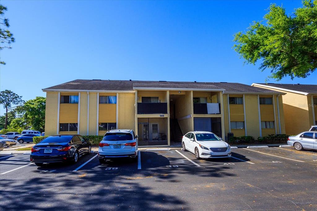A two-story apartment building with yellow siding and a parking lot in front — 908 LAKE DESTINY ROAD UNIT E, ALTAMONTE SPRINGS, FL