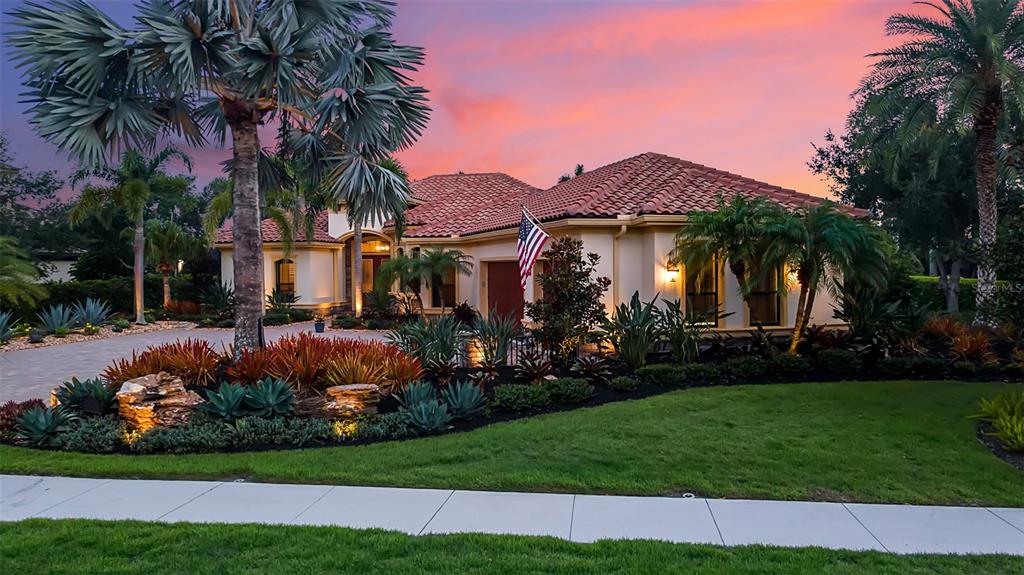 A single-story house with a tile roof and palm trees at sunset — 15114 LINN PARK TERRACE, LAKEWOOD RANCH, FL