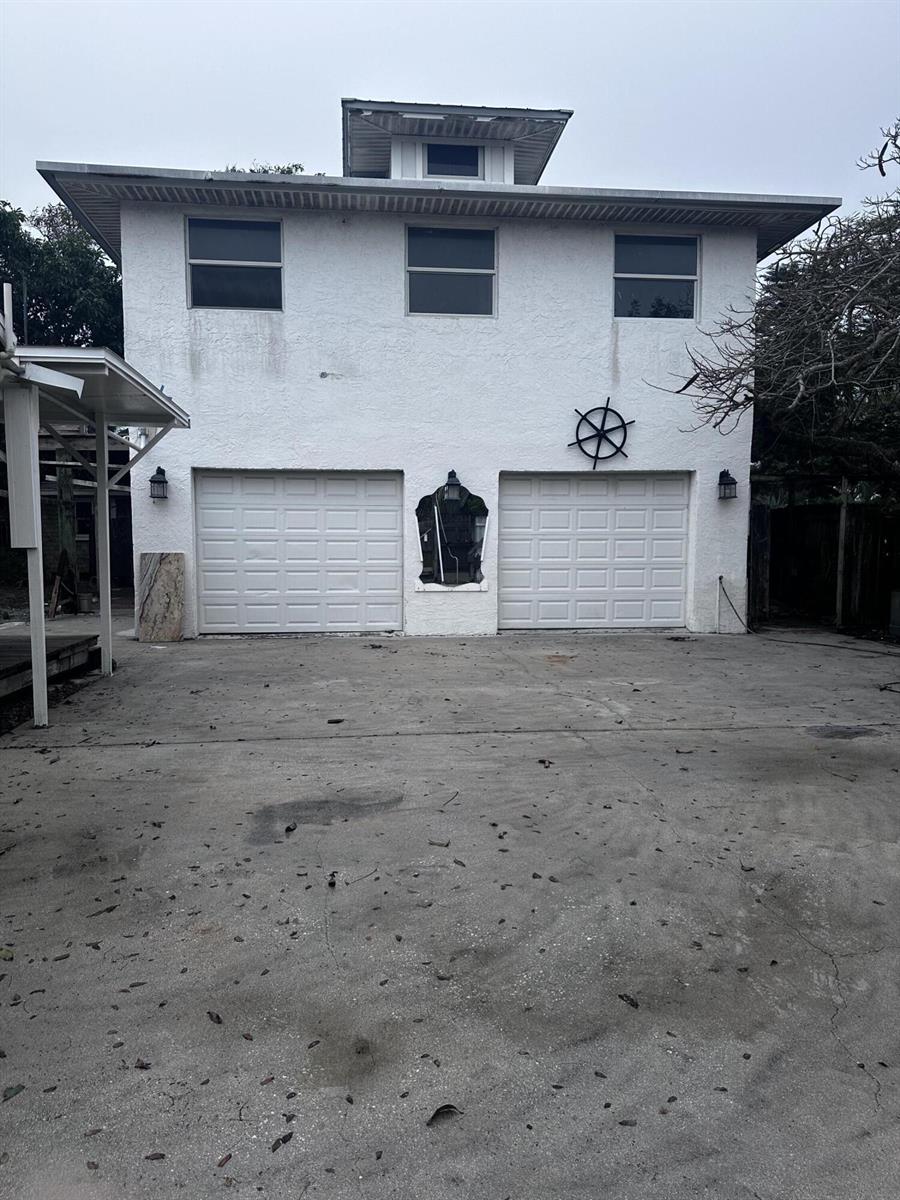 A two-story white stucco building features two garage doors, a central mirror, and a cupola — 130 NE 4th Avenue, Boynton Beach FL 33435, BOYNTON BEACH, FL