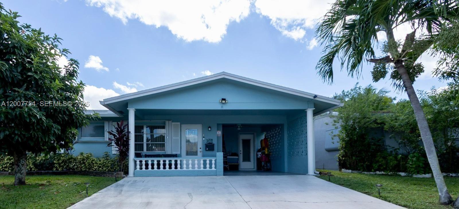 A light blue single-story house features a covered front porch and a concrete driveway — 4518 NW 45th Ct, Tamarac FL 33319, TAMARAC, FL