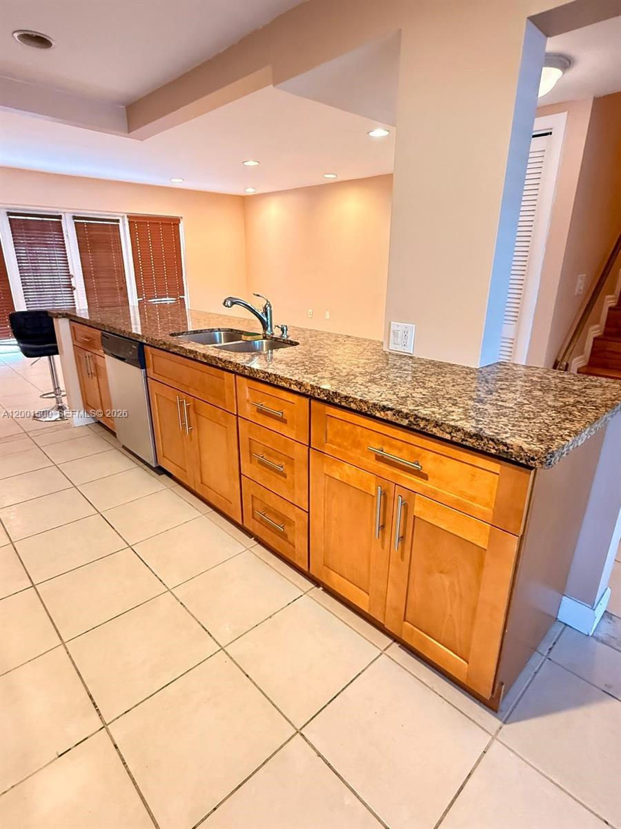 A kitchen features light wood cabinets, granite countertops, and tile flooring — 2750 N 34th Ave # 9D, Hollywood FL 33021, HOLLYWOOD, FL