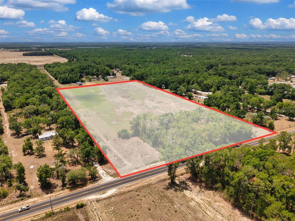An aerial view shows a large, rectangular plot of land outlined in red beside a road — 18 AC NW CR 138, BRANFORD, FL