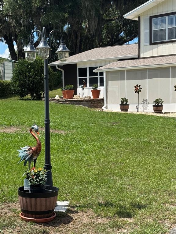 A yard features a three-headed lamp post, a decorative bird statue, and a screened porch — 30 EMERALD RUN, OCALA, FL