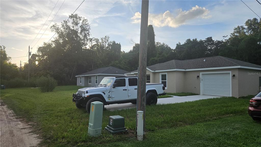 A white Jeep pickup truck is parked in the driveway of a single-story suburban house — 3745 SE 133RD PLACE, BELLEVIEW, FL