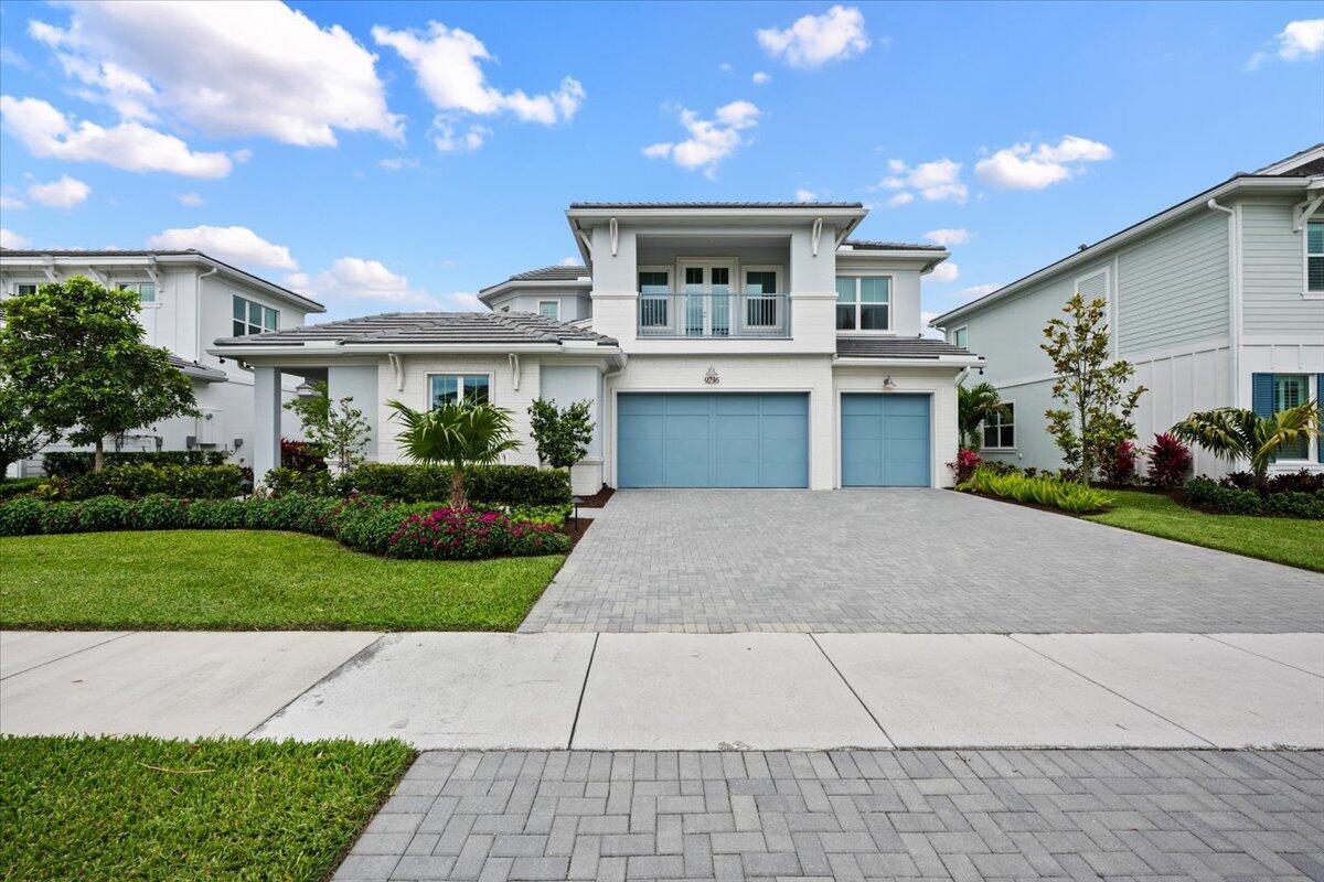 A two-story house with a blue garage, a paved driveway, and a landscaped front yard — 9236 Crestview Circle, Palm Beach Gardens FL 33412, PALM BEACH GARDENS, FL