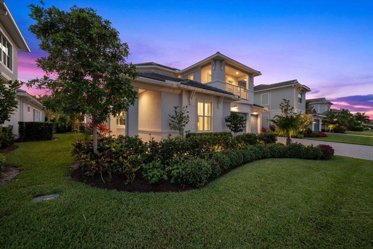 A two-story house with a landscaped front yard at dusk under a purple sky — 9236 Crestview Circle, Palm Beach Gardens FL 33412, PALM BEACH GARDENS, FL