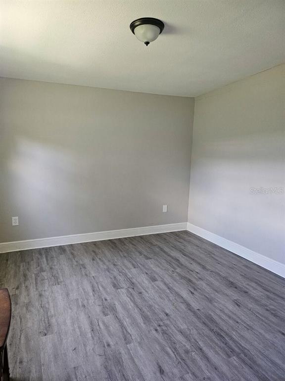 A kitchen features white cabinets, stainless steel appliances, granite countertops, and light wood-look flooring — 2390 29TH STREET NW, WINTER HAVEN, FL