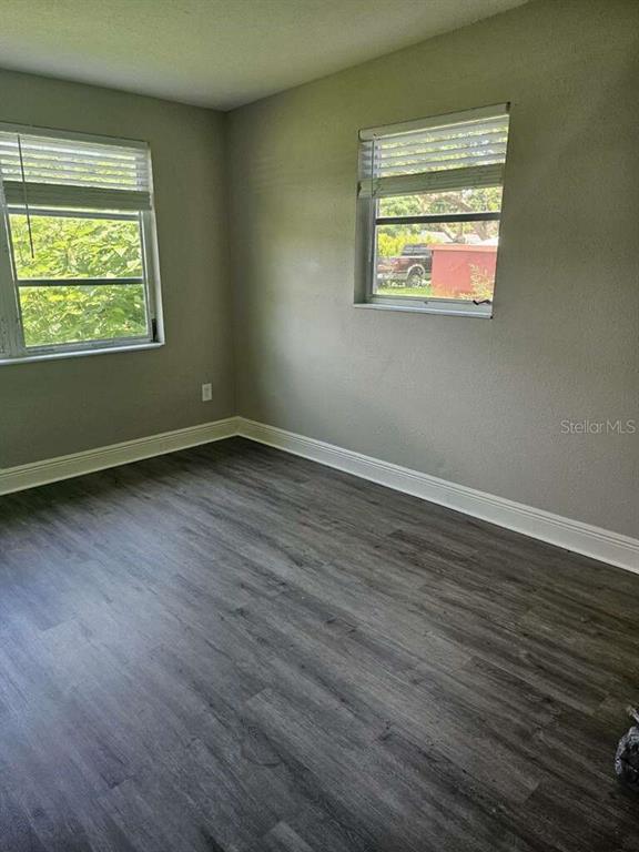 An open-concept living area features gray wood-look flooring and a kitchen pass-through counter — 2390 29TH STREET NW, WINTER HAVEN, FL