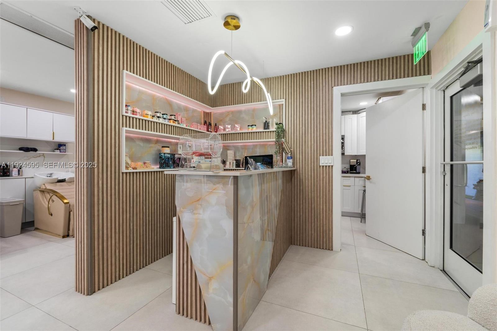 A reception area features a marble-fronted desk, slatted wood walls, and recessed shelving with lighting — 0000 SW 87th Ave, Miami FL 33165, MIAMI, FL