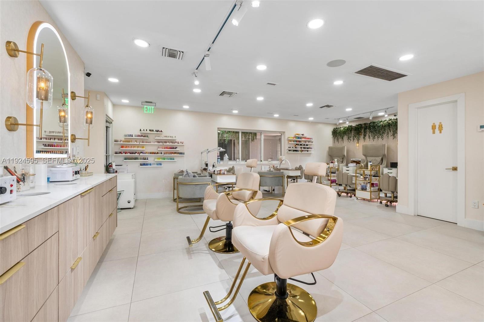 A bright nail salon features light-colored tile floors, modern chairs, and wall-mounted polish displays — 0000 SW 87th Ave, Miami FL 33165, MIAMI, FL
