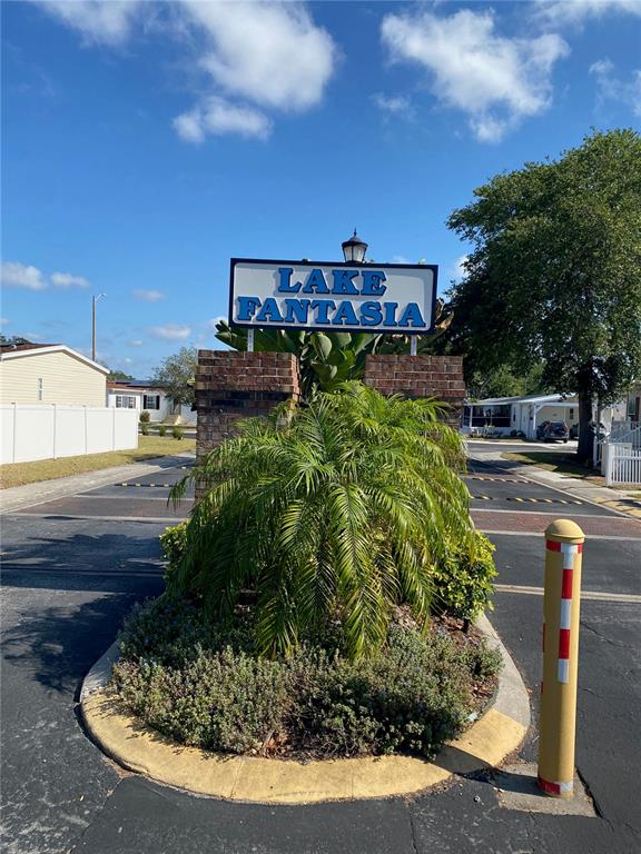 A sign for Lake Fantasia stands in front of a palm tree and paved road — 8330 FANTASIA PARK WAY, RIVERVIEW, FL