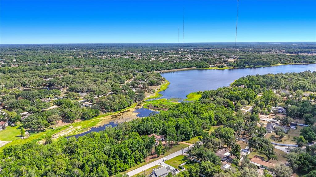 An aerial view shows a lake surrounded by dense trees and residential properties — LOT 19  LAKE HILLS DR., RIVERVIEW, FL
