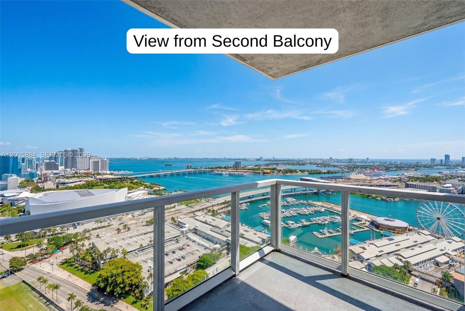A high-rise balcony overlooks a marina, a Ferris wheel, and a bridge over the water — 244 Biscayne Blvd # 3702, Miami FL 33132, MIAMI, FL