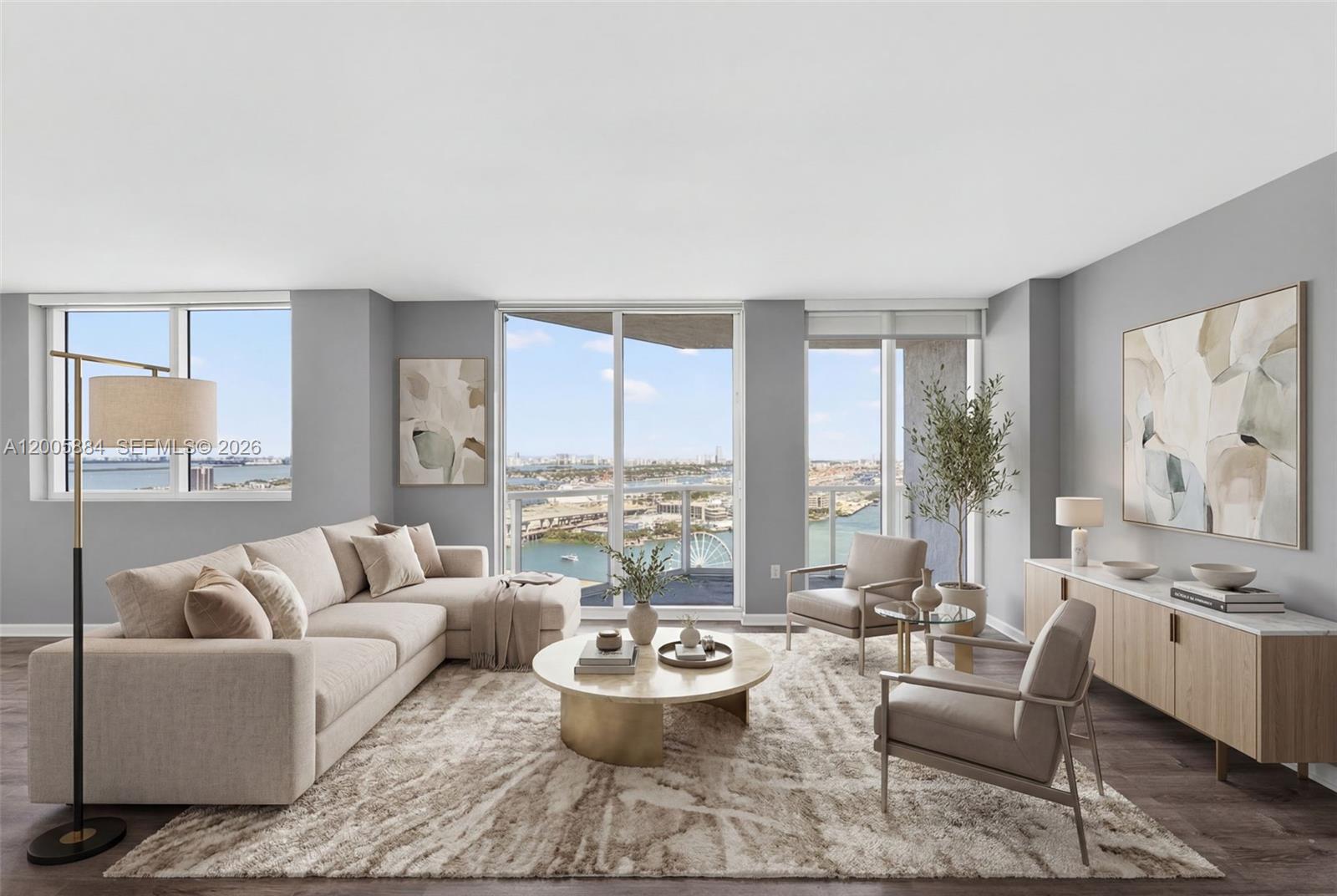 A modern living room features a beige sectional, two armchairs, and a balcony with water views — 244 Biscayne Blvd # 3702, Miami FL 33132, MIAMI, FL