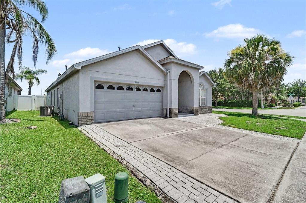 A single-story house with a gray stucco exterior, a two-car garage, and a paved driveway — 3342 CRYSTAL CREEK BOULEVARD, ORLANDO, FL