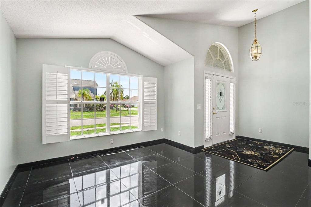 An entryway with high ceilings, black tile flooring, a large window, and a front door — 3342 CRYSTAL CREEK BOULEVARD, ORLANDO, FL