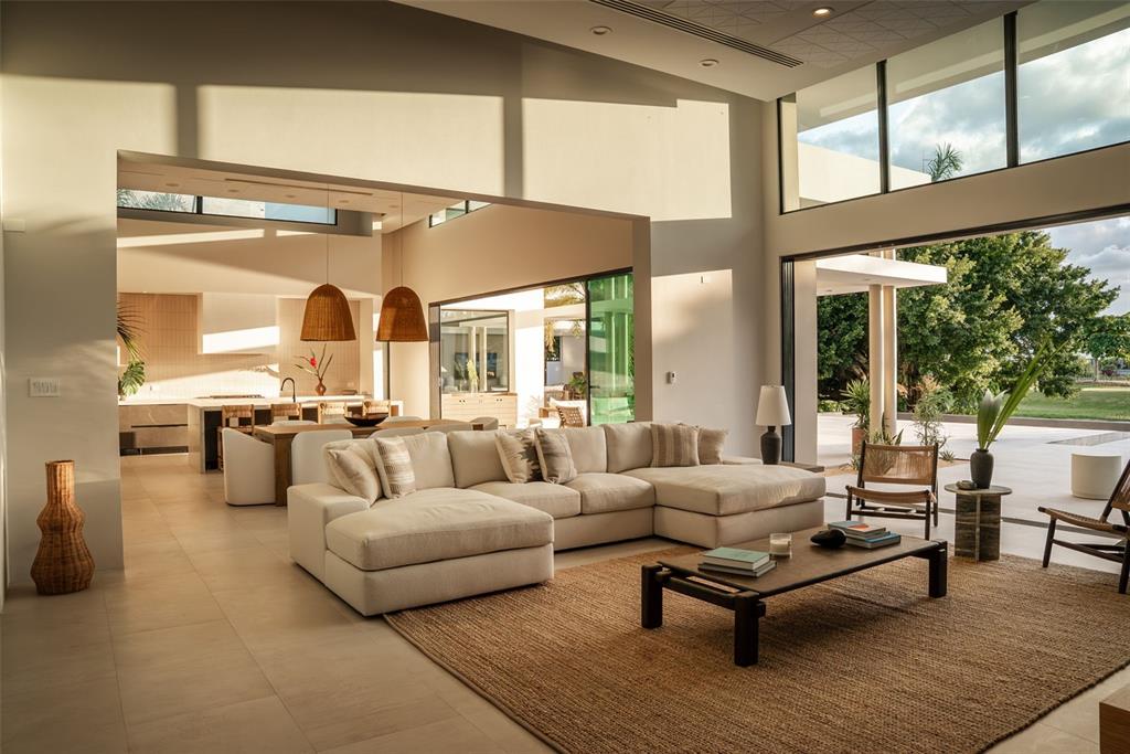 A covered patio with outdoor seating overlooks a swimming pool, a pond, and a golf course — 11 GOLF VIEW DRIVE, DORADO, PR