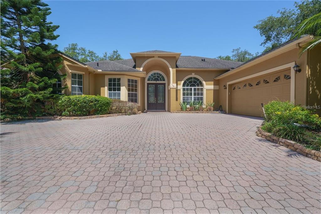 A single-story house with a paved driveway, arched entryway, and an attached two-car garage — 140 SEVILLE CHASE DRIVE, WINTER SPRINGS, FL