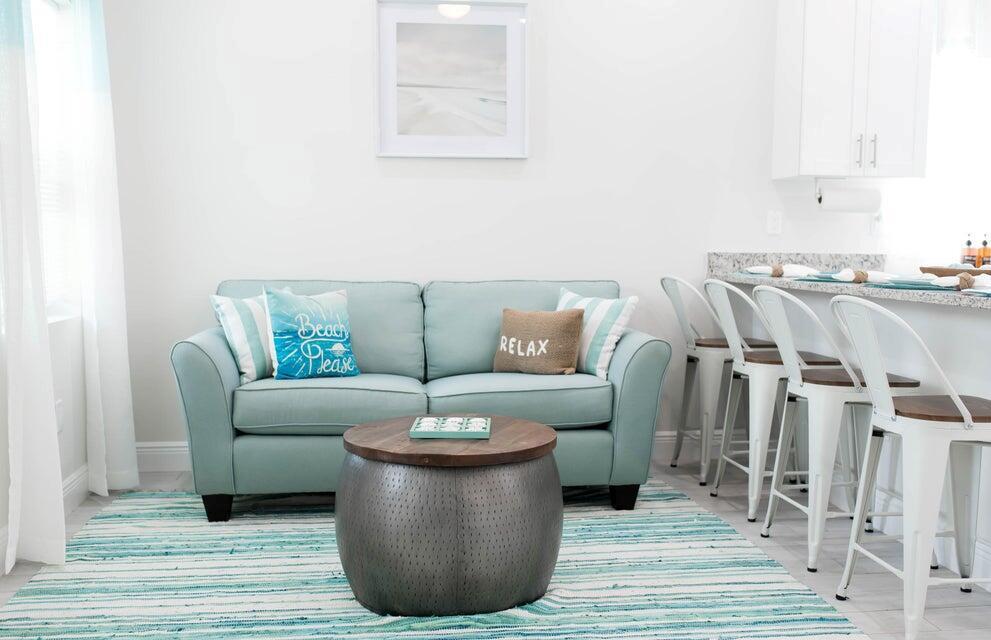 A light blue sofa sits on a striped rug in front of a kitchen bar — 2682 Nokomis Avenue, FL 33409, FL