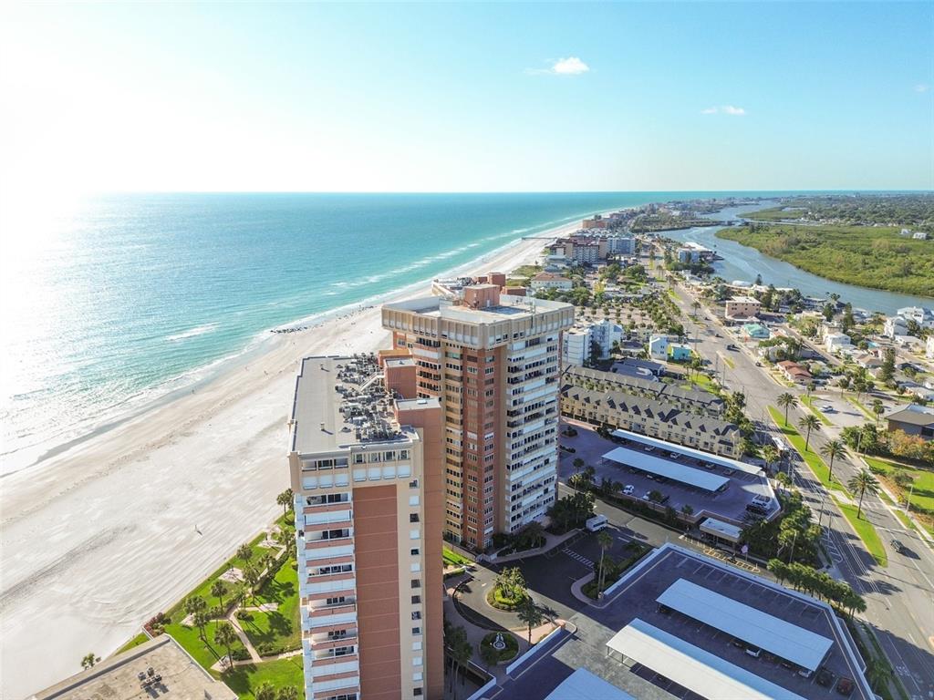 An aerial view shows two tall residential buildings situated along a sandy beach and coastline — 17920 GULF BOULEVARD UNIT 208, REDINGTON SHORES, FL