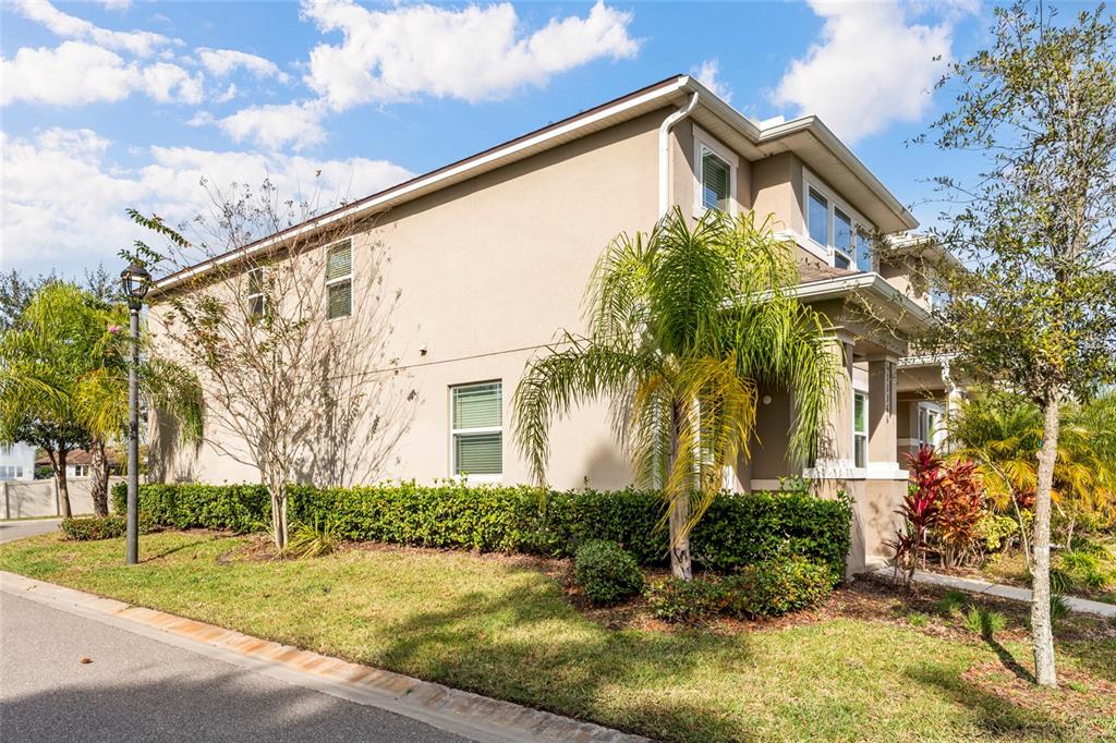 A two-story beige stucco townhouse with a palm tree and landscaping in the front yard — 13366 ABUELA ALLEY, WINDERMERE, FL