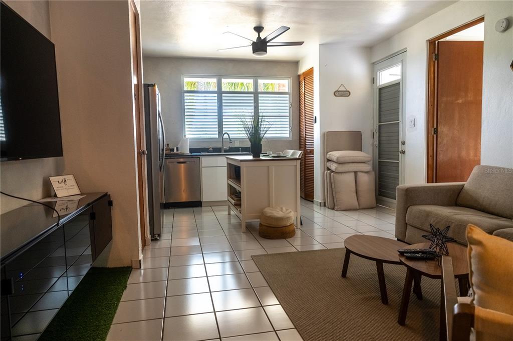 A kitchen and living area with white tile floors, a kitchen island, and a sofa — PR-713 KM 2.5 COND. EL LEGADO GOLF RESORT UNIT 2412, GUAYAMA, PR